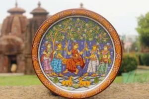 Traditional painted decorative wall plate with five figures in traditional attire beneath a tree, ornate orange floral border, multicolor palette